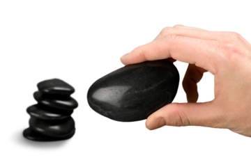 Human hand holds black zen stone