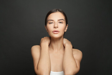 Obraz premium Portrait of perfect nice woman with clean shiny fresh skin against black studio wall background