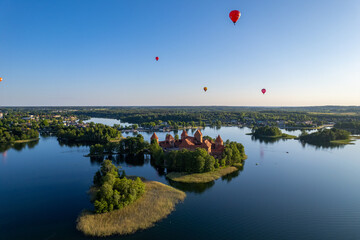 Aerial summer sunny sunset view of Trakai Island Castle and hot air balloons, Lithuania