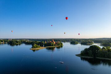 Aerial summer sunny sunset view of Trakai Island Castle and hot air balloons, Lithuania