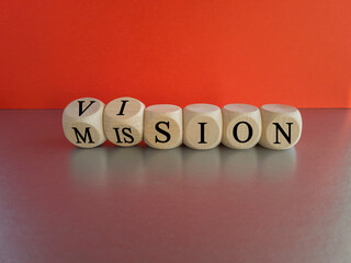 Turned wooden cubes and changed the word 'mission' to 'vision'. Beautiful grey table, red background, copy space. Business concept.