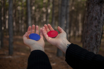 Woman holding biomagnetism magnets in the forest. Hands of young woman holding biomagnetism magnets. Concept of woman using magnets in nature.  - obrazy, fototapety, plakaty