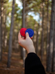 Woman holding two biomagnetism magnets in the forest. Hand of young woman holding biomagnetism...