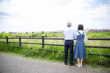 日本人ミドル夫婦の後ろ姿、公園で手を繋ぎ全身