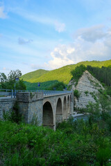 old bridge over the river Enza in Neviano degli Arduini, Parma, Emilia Romagna, Italy during the...