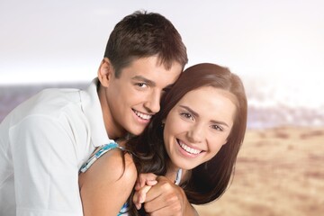 Young happy cute loving couple on beach background