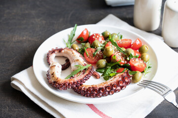 salad with octopus, tomatoes, olives and arugula. fresh healthy salad