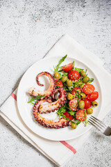 salad with octopus, tomatoes, olives and arugula. fresh healthy salad