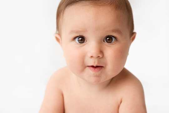 Close-up portrait of funny infant baby with puzzled expression