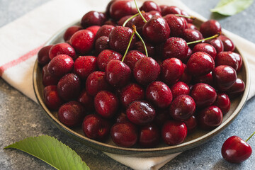 Composition of sweet cherries on a plate with water drops. Summer and harvest concept. Cherry macro. Vegan, vegetarian, raw food