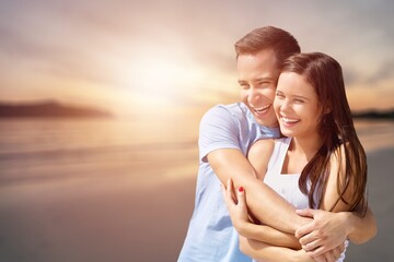 Young happy cute loving couple on beach background