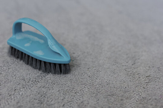 purity and cleaning concept - close up of cleaning brush on the carpet