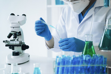 Fototapeta premium Lab work, Doctor holds a test tube takes the test from a test tube in analysis, blood, DNA, test tube stand.