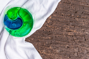 colored capsule for washing clothes on a white t-shirt, close-up