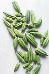 Top view of okra on a white background, lady fingers on a marble countertop, okro being prepared for cooking