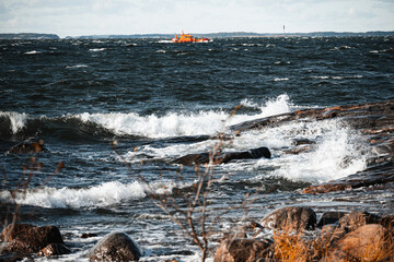 Ocean during a heavy tidal waves, a vessel in the background