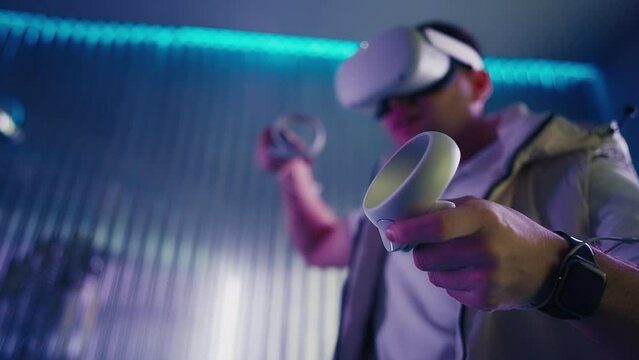 Player in virtual reality headset uses two game controllers