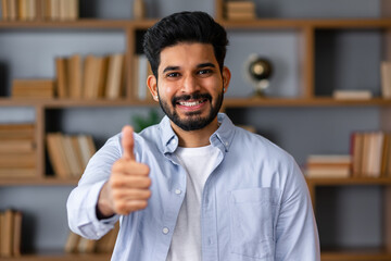 Young arab handsome man wearing casual clothes doing happy thumbs up gesture with hand. approving expression looking at the camera showing success.