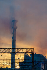 Industrial smoke from the chimney of a power plant at sunset