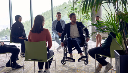 A businessman in a wheelchair in the center of the circle, passionately sharing his business ideas...