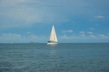 Obraz premium White yacht boat sail on turquoise water blue sky with cloud