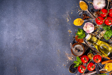 Spices for cooking on dark background . Different seasonings, spices and herbs paprika, pepper, turmeric, salt, basil, mint, cinnamon, garlic and other aromatic ingredients for preparation food