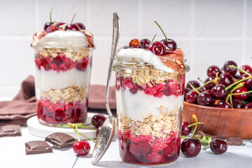  Overnight cherry oatmeal in jar. Sweet and sour breakfast oat porridge, with oats flakes.  vanilla yogurt and cherries