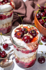  Overnight cherry oatmeal in jar. Sweet and sour breakfast oat porridge, with oats flakes.  vanilla yogurt and cherries