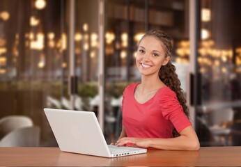 Young and happy woman working in office on laptop