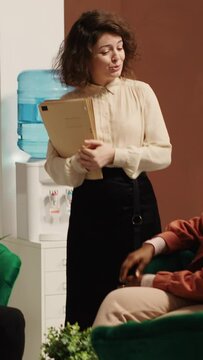 Vertical Video Hospitality manager upselling tourists, suggesting hotel extras and room upgrades, trying to accommodate any special request. Guests discussing booking options while being checked in