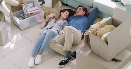 Planning, boxes and couple on floor of new house, dream life and mortgage on property investment. Moving, man and woman relax in home, investing in real estate and plan for love and future together.