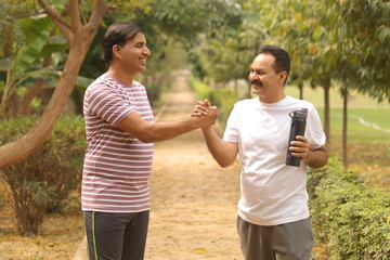 old Indian friends jogging in park. Both are health conscious and running on the jogging track and trail.