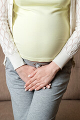 close up of pregnant women urine urgency at home. pregnant urinary incontinence concept