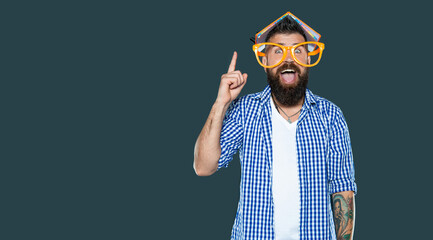 amazed inspired with idea funny bearded man in party glasses with book on head