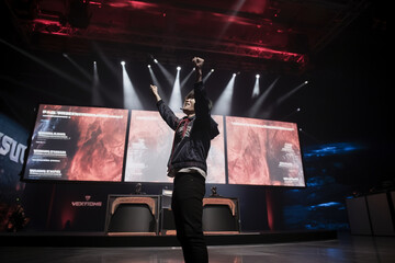 A player standing in front of a large screen displaying the winning message, raising their arms triumphantly Generative AI