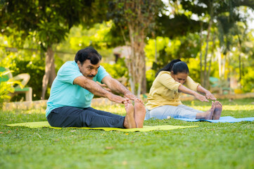 Indain senior couple at morning doing yoga at park - concept of healthy active lifestyle, outdoor...