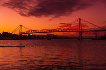 Fototapeta na wymiar Hercilio luz bridge and warm sunset with colorful sky in Florianopolis