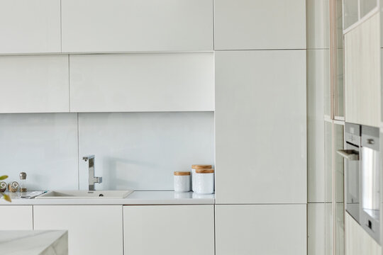 Horizontal image of white bright kitchen with beautiful design and big cupboard