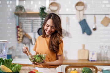 Young Asian woman is preparing a fresh healthy vegan salad with many vegetables in the kitchen, Dieting Concept. Healthy food Lifestyle. Cooking At Home.