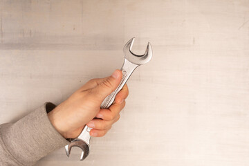  Wrench in hand closeup on white background