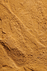 Decorative brown ocher putty background. Wall texture with filler paste applied with spatula, chaotic dashes and strokes over plaster. Creative design, stone pattern, cement.