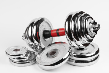 Metal demountable dumbbell with black plates and red handle isolated on white background