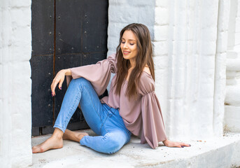 Portrait of a young beautiful brunette woman in blue jeans