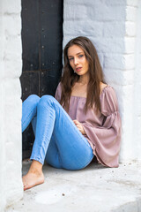 Portrait of a young beautiful brunette woman in blue jeans