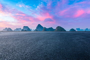 Asphalt road platforms and karst mountain with red clouds at sunrise