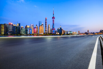 Asphalt road and city skyline with modern architecture in Shanghai, China.