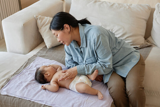 High angle view of Asian mother caring about her newborn baby, they spending time at home