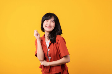 Portrait beautiful young asian woman cute and shy dressed in orange clothes isolated on yellow studio background.