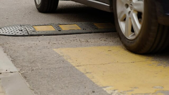 Blue Car Passes Speed Bumper on Street Road. Pedestrian Safety and Speed Control