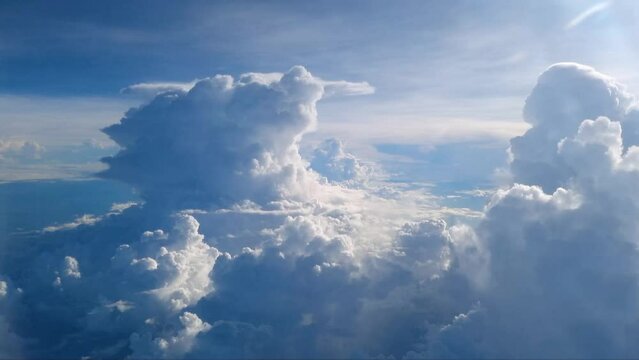 Point of view from the airplane, Blue sky and white clouds from airplane look through window above cloud background. Traveling and tourism